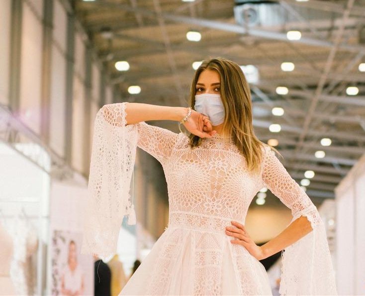 A model wearing a face mask presents a wedding dress at the European Bridal Week trade fair in Essen, Germany.  (Photo by Tang Ying/Xinhua)